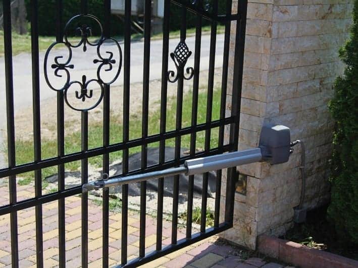 A képen egy kapu látható melyhez kapcsolódik egy kapunyitó motor mely segítségével a kapu automatizálható nyitásra és zárásra